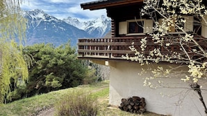 Una cabaña de madera con balcón que da a un paisaje montañoso.