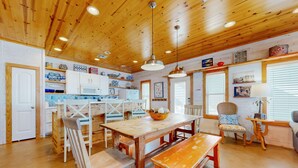 A wooden interior with a dining table, benches, and chairs. - Spacious Home in Town, Back Patio, Shared Pool, Golf Cart Accessible (Port Aransas)