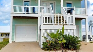 A two-story house with a balcony, a garage, and a small garden area.