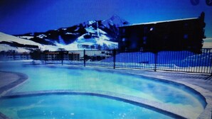 Una piscina con borde curvo y vista a un edificio al fondo.