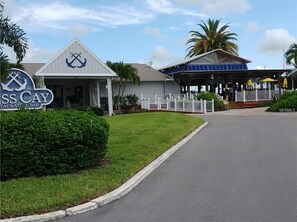 Un bâtiment sur lequel on peut lire l’inscription « ISS CAY RESTAURANT & BAR », et qui dispose d’un espace extérieur abrité avec des tables.