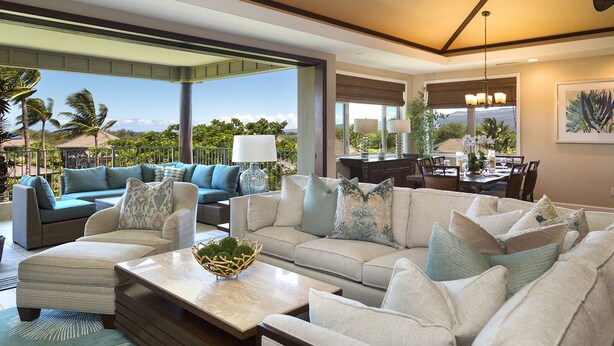 A spacious living room with a large sofa set, a coffee table with a decorative bowl, and a dining area with a table and chairs. - Breathtaking Luxurious Pacific Island Home (Waimea)