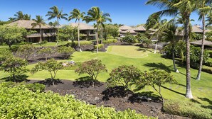 A golf course with a putting green, surrounded by palm trees and well-maintained lawns. - Breathtaking Luxurious Pacific Island Home (Waimea)