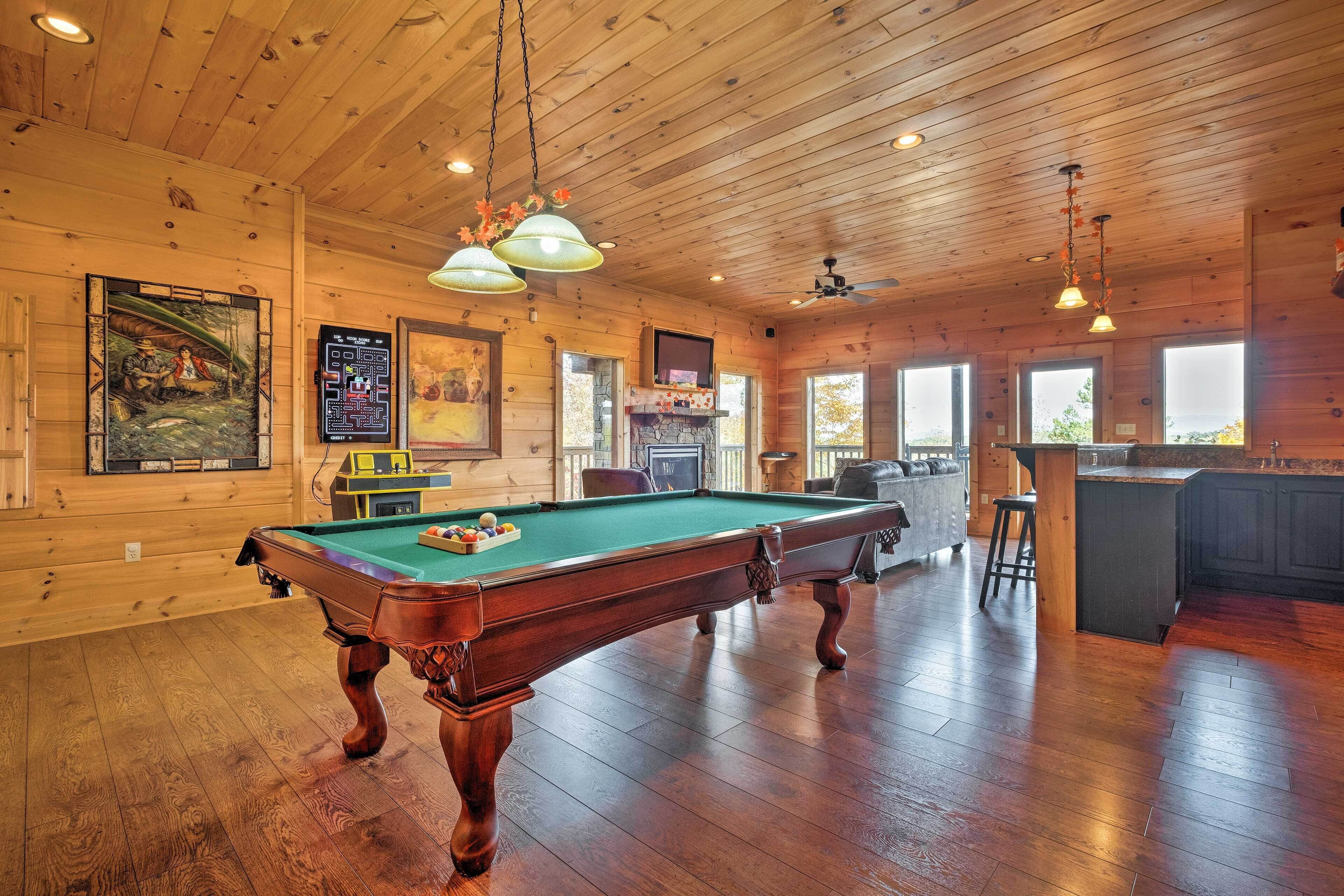 Un intérieur en bois avec une table de billard, un plafond en bois et de grandes fenêtres.