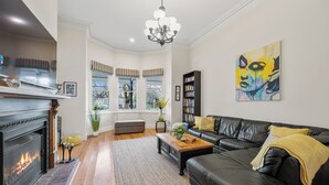 Un salon avec une cheminée, un canapé en cuir et une bibliothèque.