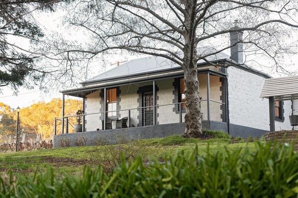 Stunning two-story building with a tree-lined lawn and a charming balcony.