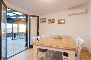 Enjoy meals in this dining area with a wooden table and comfortable seating for all.