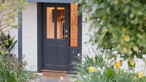 A dark-colored front door with a glass panel, a small window above it, and a doorbell. - The Other House (Piccadilly)