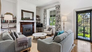 A living room with a fireplace, a sofa, a chair, and a coffee table. - The Other House (Piccadilly)