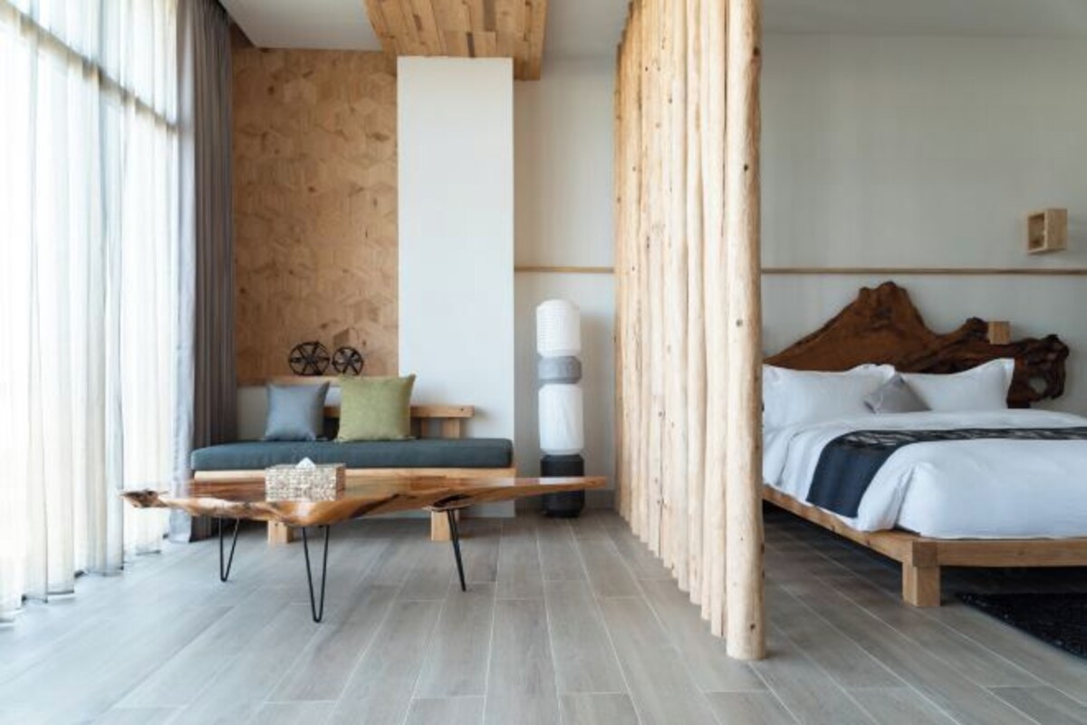 Un dormitorio moderno con una cama de madera, un sofá verde y una mesita de centro de madera.