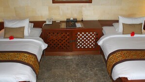 A hotel room with two beds, a small wooden desk, a telephone, and a decorative wall piece. - Beautiful Property in Tegalalang Rice terrace (Bali)