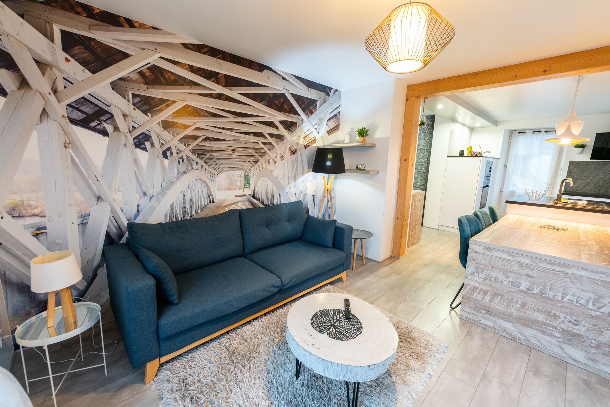 Ein modernes Wohnzimmer mit einem dunkelblauen Sofa, einem runden Couchtisch und einer weißen Lampe.