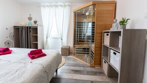 Ein Schlafzimmer mit Bett, Kleiderschrank, begehbarem Kleiderschrank und einem Fenster mit Vorhängen.
