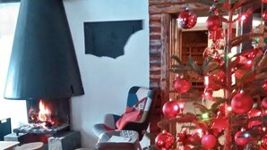 Un soggiorno accogliente con camino, albero di Natale e mobili in legno rustico.