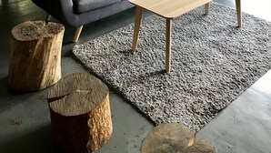 Un accogliente soggiorno con divano, tavolino e sedie in legno.