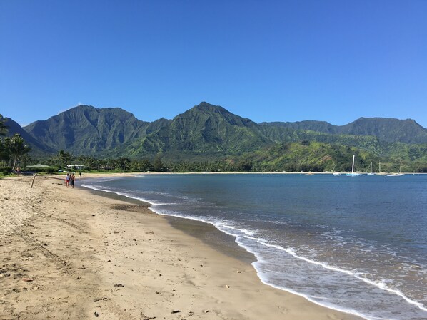 A beach with mountains in the background, clear skies, and a calm sea. - Escape to Tropical Bliss, Our Dreamy Oasis at the Plantation at Princeville (Princeville)