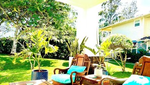 A patio with wooden furniture and potted plants.