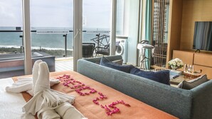 A hotel room with a bed, a sofa, a balcony with a view of the sea, and a TV. - Albion Residence Haitang Bay Sanya (Sanya)