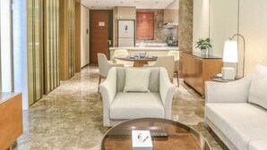 A modern hotel room with a dining area, a sofa, a coffee table, and a lamp. - Albion Residence Haitang Bay Sanya (Sanya)