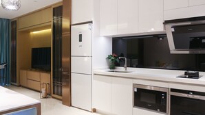 A modern kitchen with white cabinetry, a built-in oven, and a microwave. - Albion Residence Haitang Bay Sanya (Sanya)