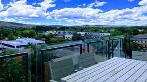 A balcony with a view of a residential area, including houses and greenery under a partly cloudy sky. - Staying Places - The Avenue (Turner)