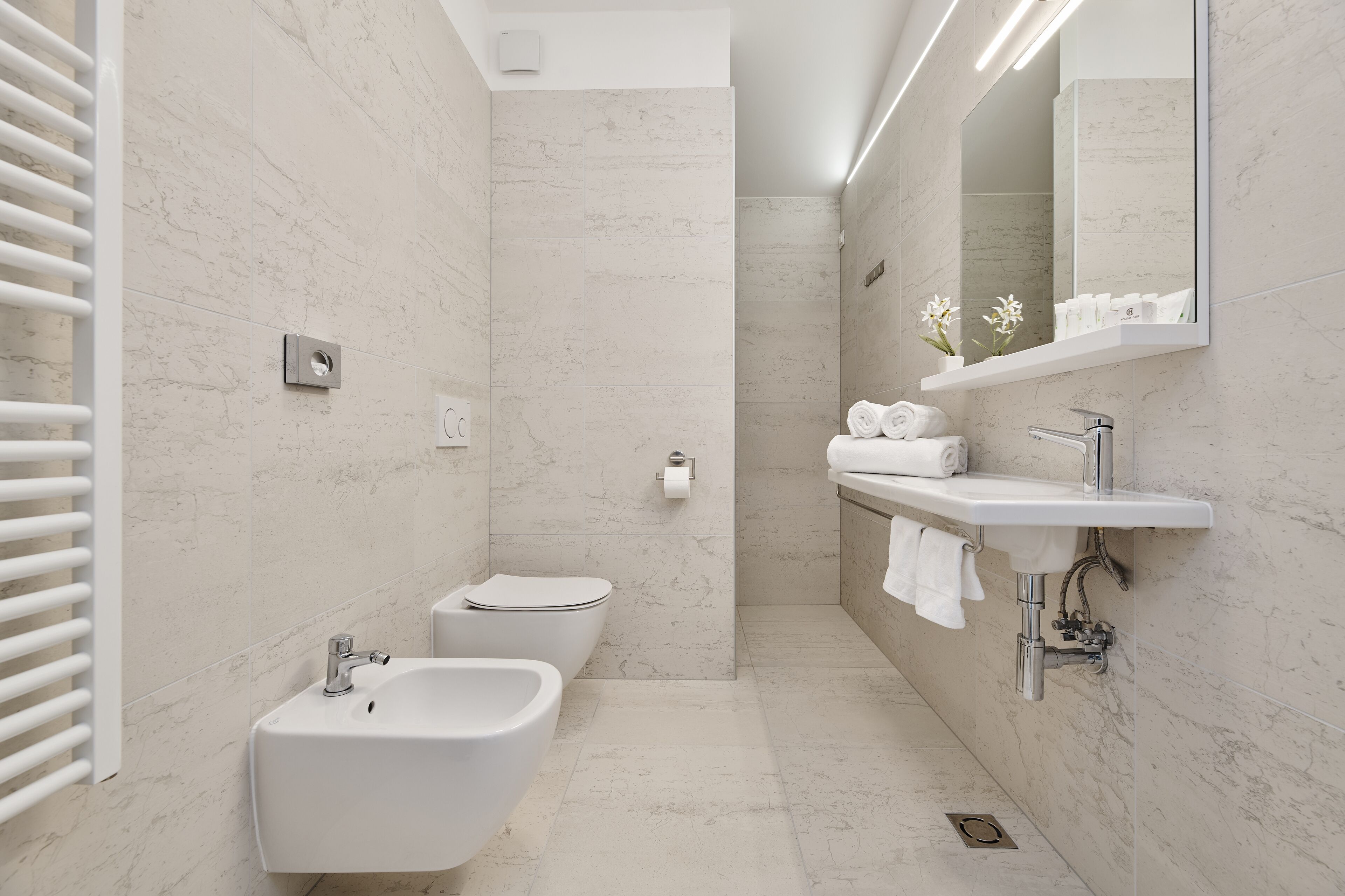 Un baño moderno con bidé, lavamanos e inodoro.