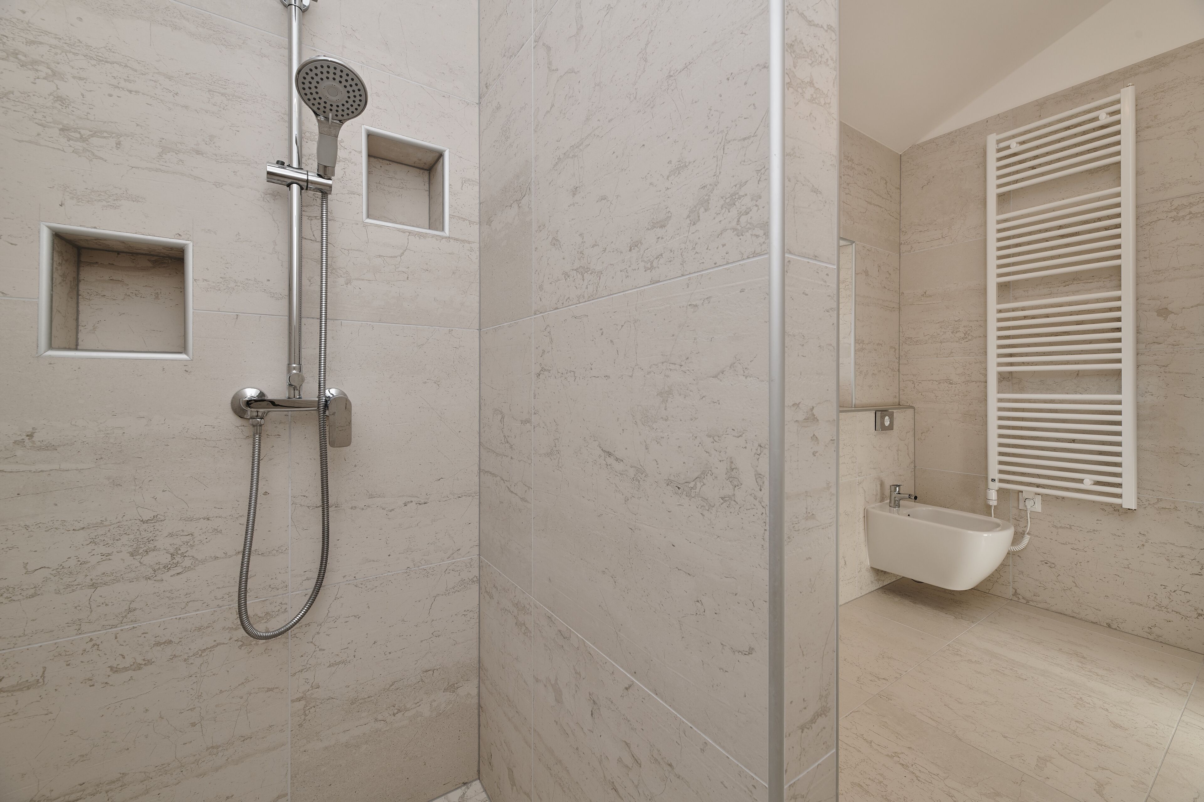A modern bathroom with a glass-enclosed shower, a built-in sink, and a towel rack.