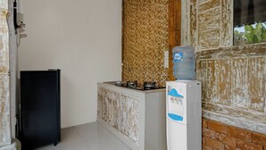 Una cocina con refrigerador, dispensador de agua y salpicadero de azulejos.