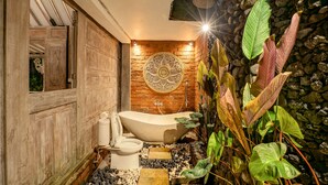 Un baño con una bañera independiente, un inodoro y un zócalo decorativo.
