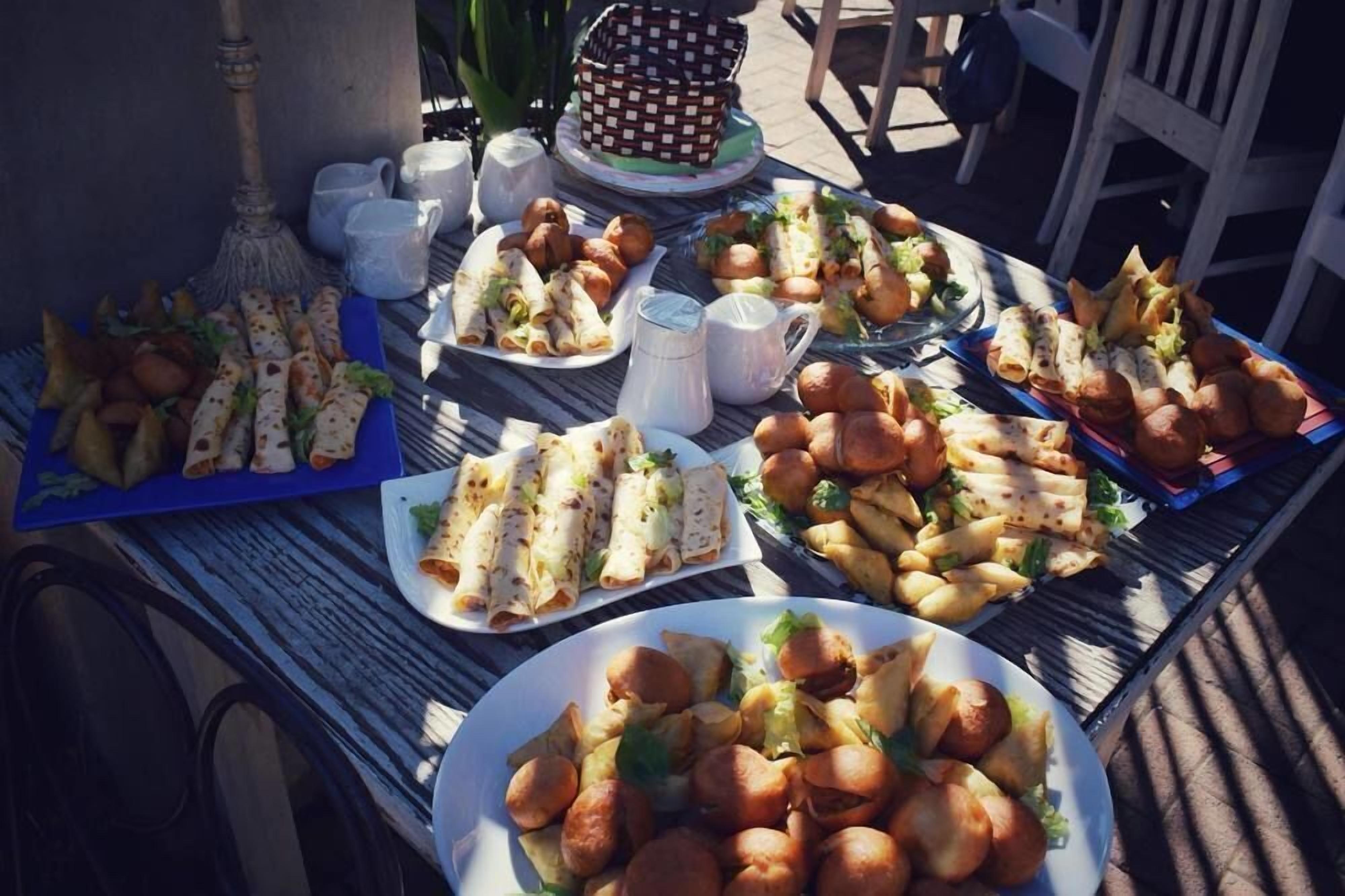 A table with various food items including wraps, rolls, and pastries, suggesting a buffet or picnic setting.