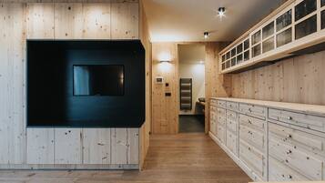 Cocina moderna con paneles de madera, encimera negra y muebles empotrados.