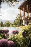 Una piscina al aire libre, sombrillas, sillones reclinables de piscina