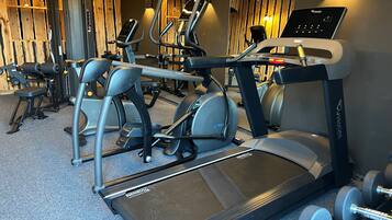 A gym with treadmills, elliptical machines, and free weights.