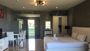 A hotel room with a bed, a desk, a chair, a wardrobe, and a bathroom visible through an open door. - Apartment in Aonang & Railay Sea View (Krabi)