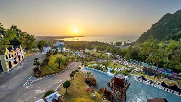 A coastal resort with a road leading to a marina, surrounded by lush greenery and a sunset view. - Apartment in Aonang & Railay Sea View (Krabi)
