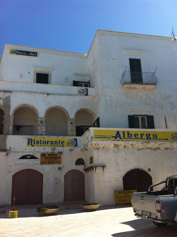 Un edificio con un letrero de Ristorante, una entrada visible y un camión estacionado.