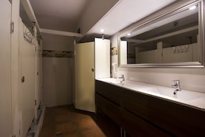 A bathroom with a white sink, a mirror, and a door leading to a shower area. - Go BCN Hi Sants - Hostel (Barcelona)
