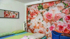 A bedroom with a bed, pillows, a chair, and a floral wallpaper. - Go BCN Hi Sants - Hostel (Barcelona)