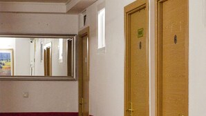 A hotel room with a red sofa, wooden doors, and a mirror on the wall. - Go BCN Hi Sants - Hostel (Barcelona)