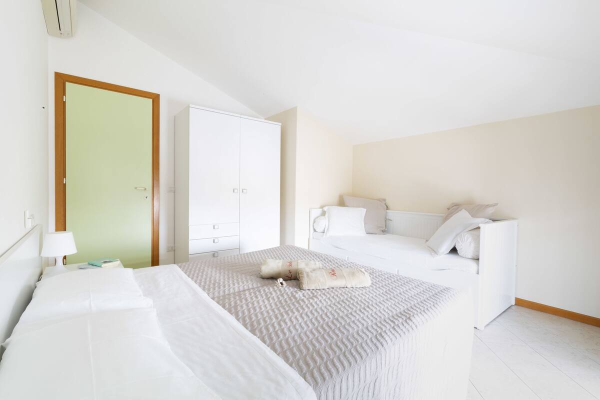 A bedroom with a bed, a wardrobe, and a nightstand.