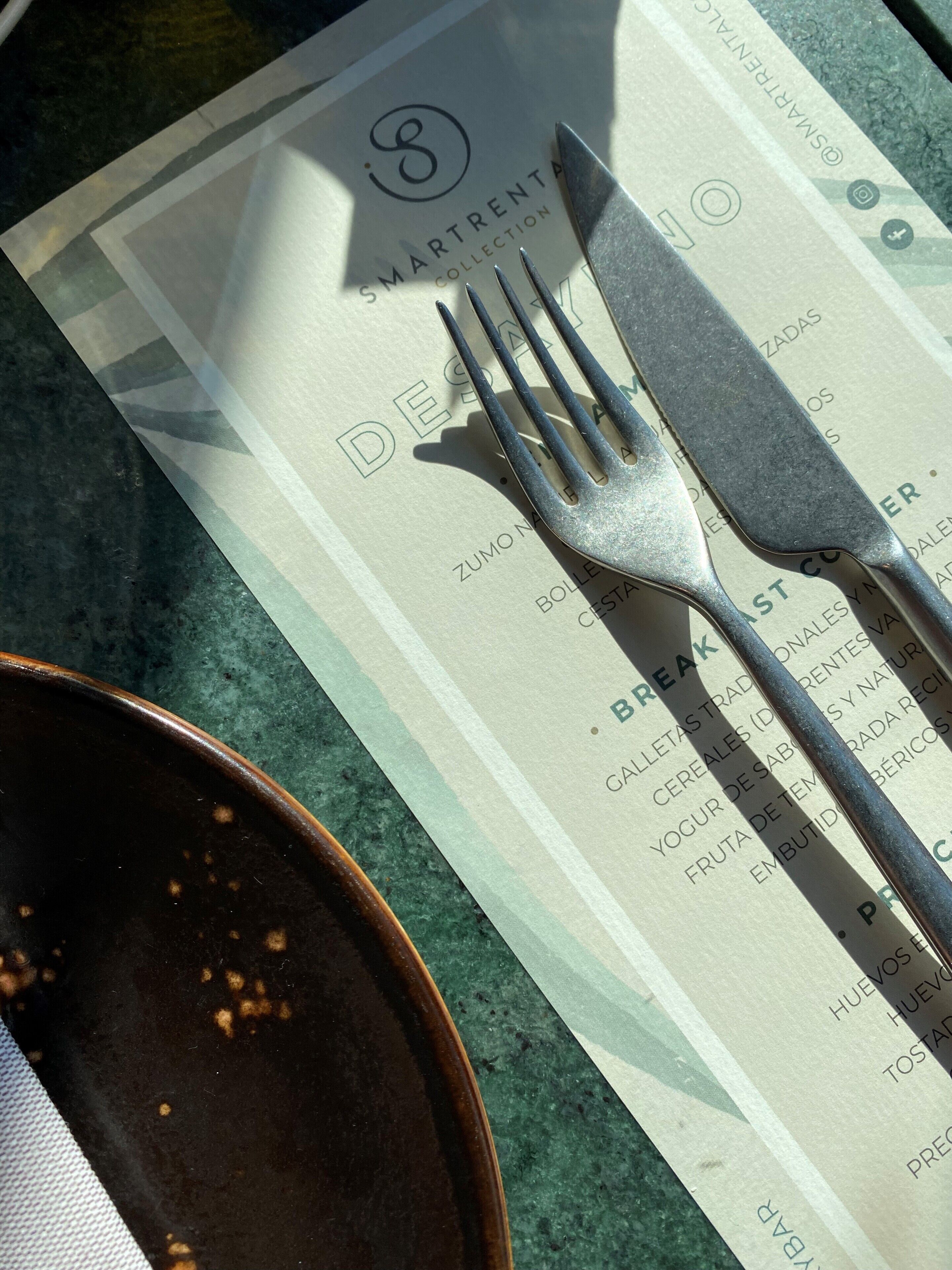 Un menu avec une fourchette et un couteau posés sur une table.