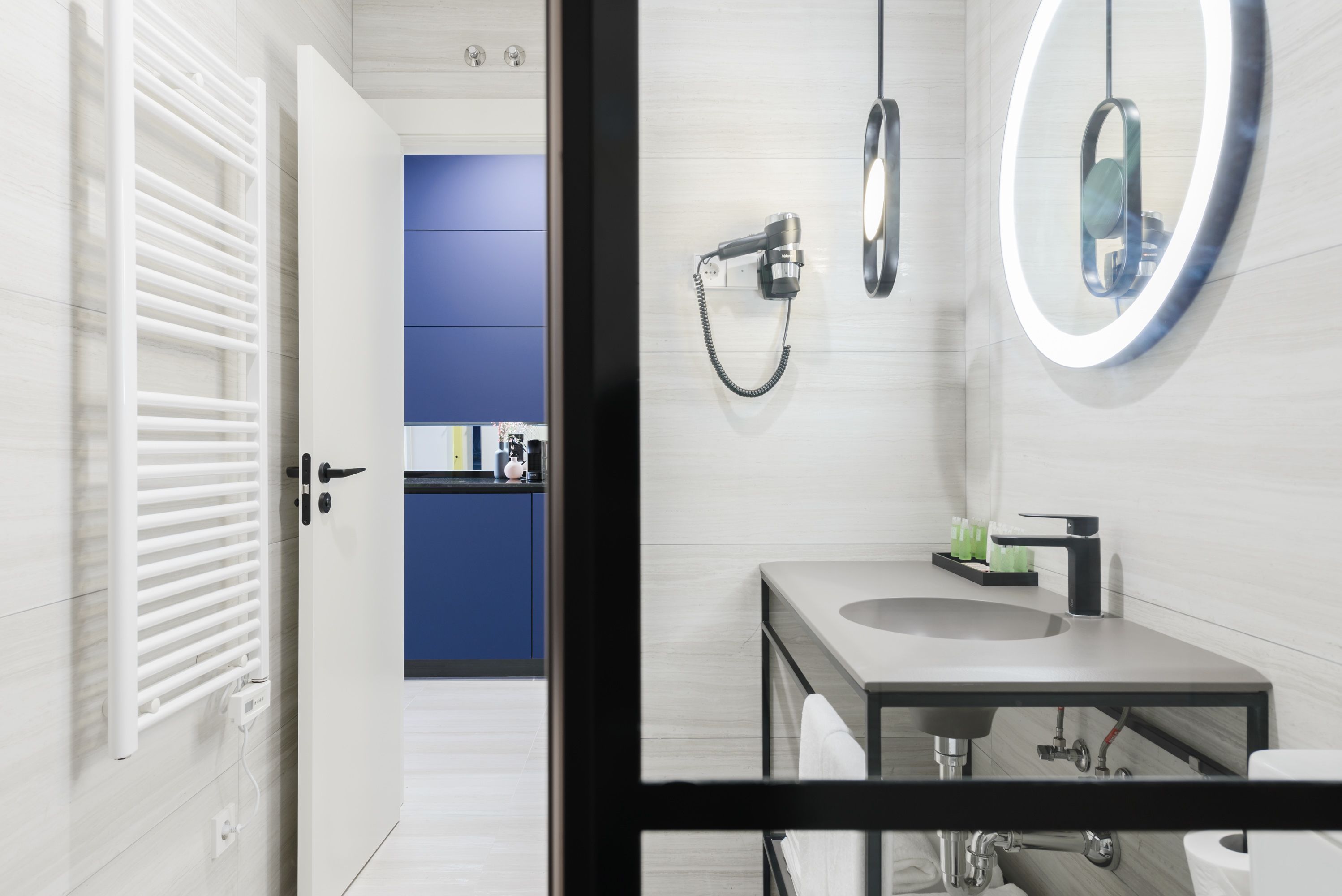 Un baño moderno con lavabo, espejo y toallero.