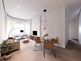 Una sala de estar moderna con sofá, televisor, mesa de comedor, sillas y una planta en maceta.
