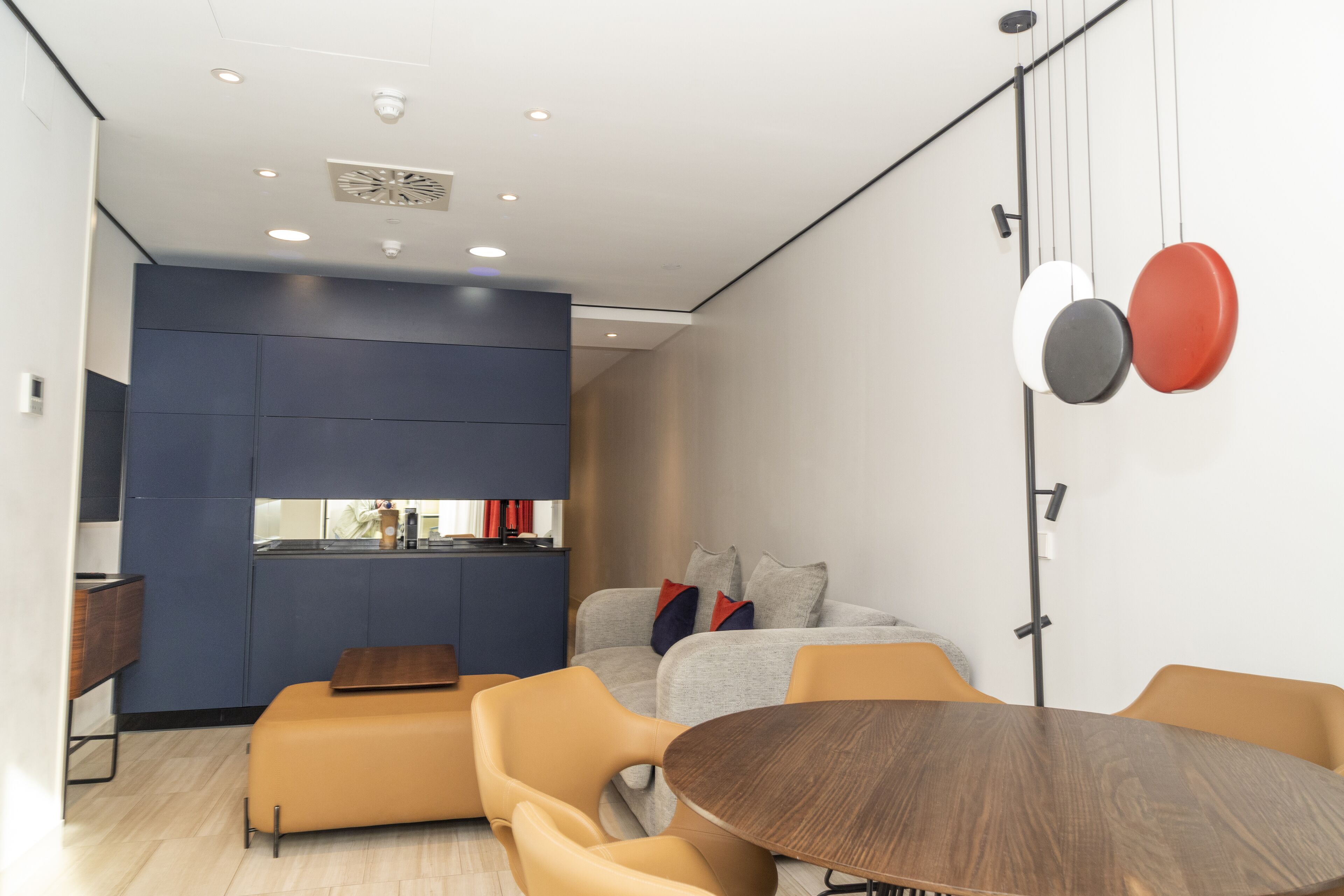 Un interior modern amb zona de menjador, un sofà i una barra de cuina.