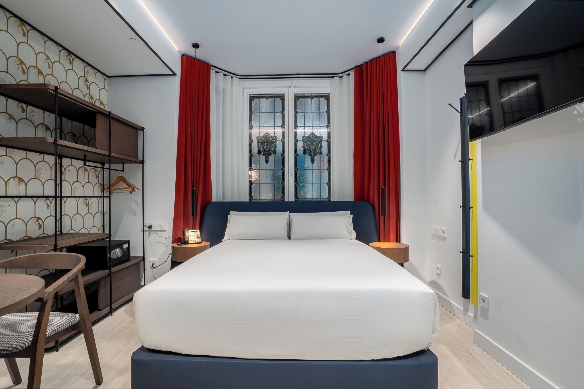 Une chambre d’hôtel moderne équipée d’un grand lit, d’un bureau avec une chaise et d’une armoire.