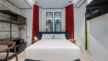Une chambre d’hôtel moderne équipée d’un grand lit, d’un bureau avec une chaise et d’une armoire.