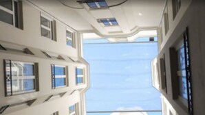 Un immeuble à plusieurs étages, doté de nombreuses fenêtres et offrant une vue sur le ciel.