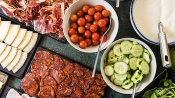 Diverses opcions de menjar, com talls de carn, tomàquets, cogombre i formatge.