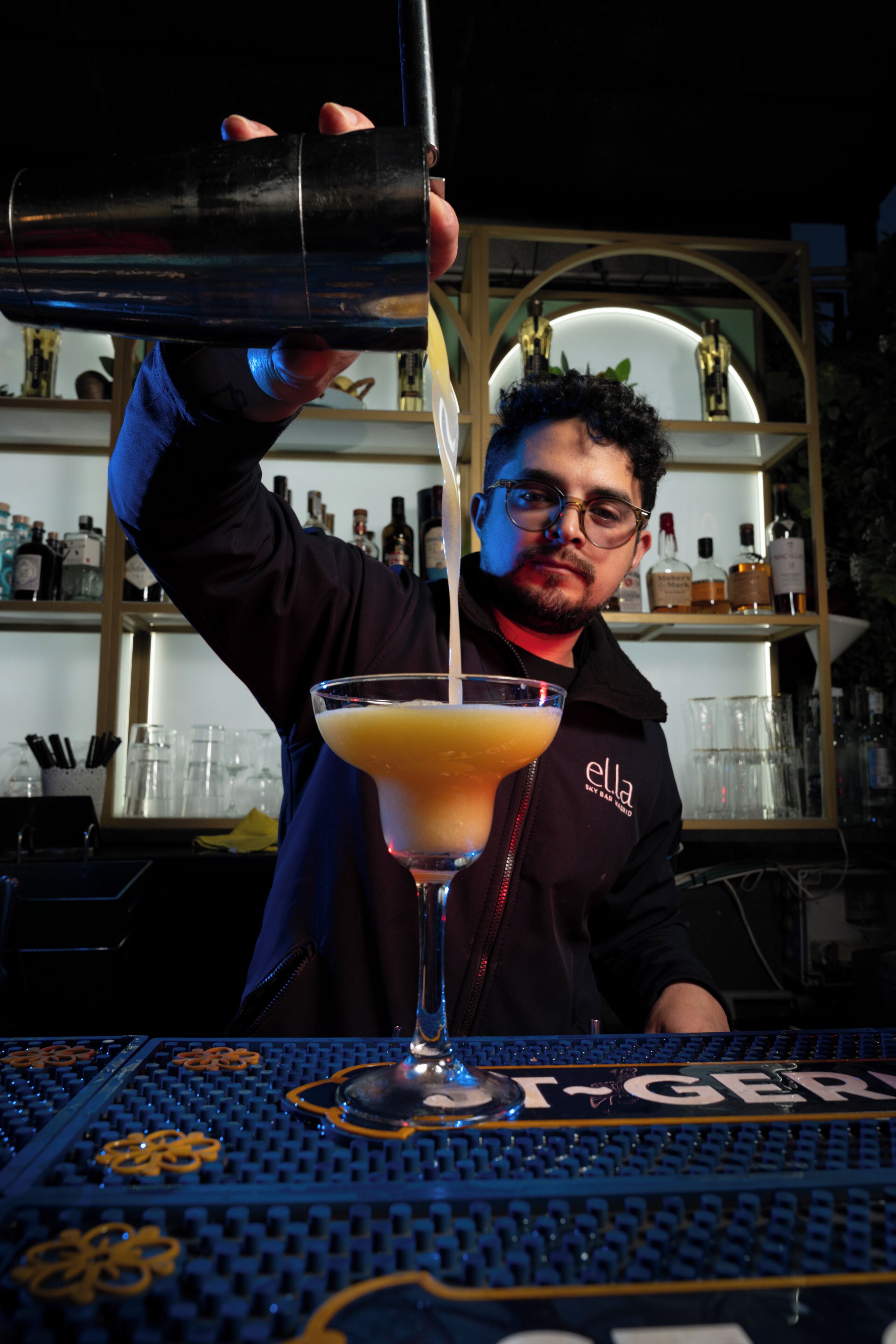 Un barista versa una bevanda in un bicchiere da martini.