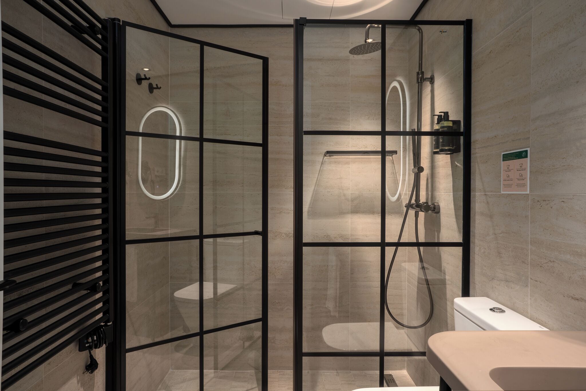 A modern bathroom with a glass-enclosed shower, a toilet, and a sink.